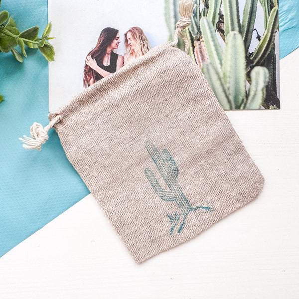 Textile pouch with cactus design on a light blue and white background