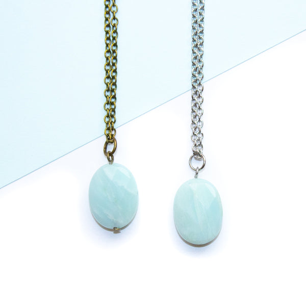 Two necklaces with amazonite stones on a light blue and white background