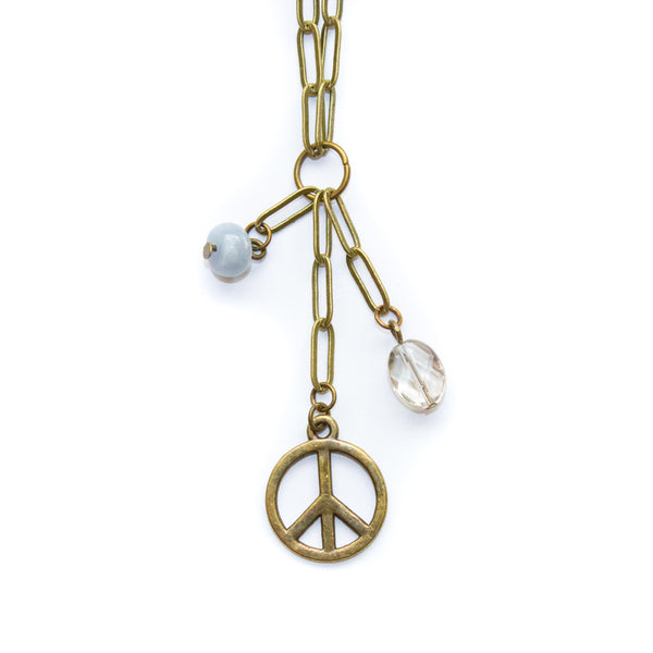 Necklace with peace symbol pendant and gemstone beads on a white background