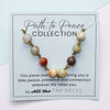 Beaded amazonite necklace on a card with 'Path to Peace Collection' text, featuring All the Tiny Pieces branding.