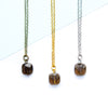 Three necklaces with square smoky quartz gemstones on a light blue and white background
