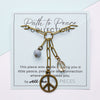 Brass chain necklace with peace symbol pendant on a 'Path to Peace' card