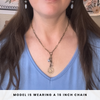 Woman wearing a necklace with a peace sign pendant, text indicating chain length.