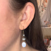 Close-up of an ear wearing a dangling earring with beads.